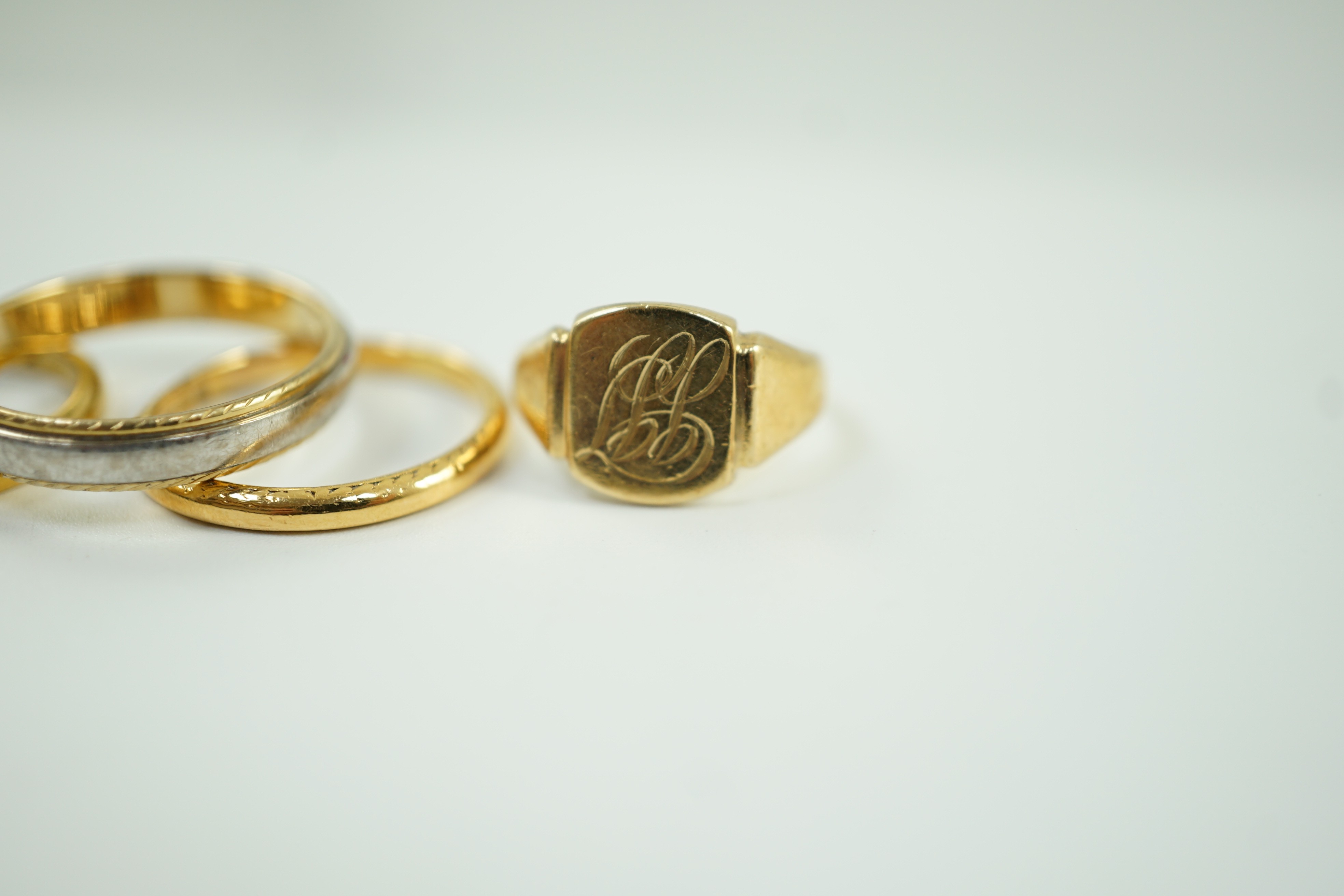 Two 22ct gold wedding bands, 5.2 grams, a 9ct gold signet ring, 2.4 grams and a two colour 750 yellow metal band, 4.4 grams.